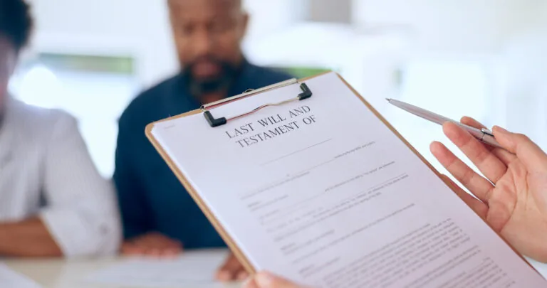 Hand, document or testament in office by closeup for last will, insurance of funeral planning for family future. Safety, security or protection of married couple in home for preparation of health